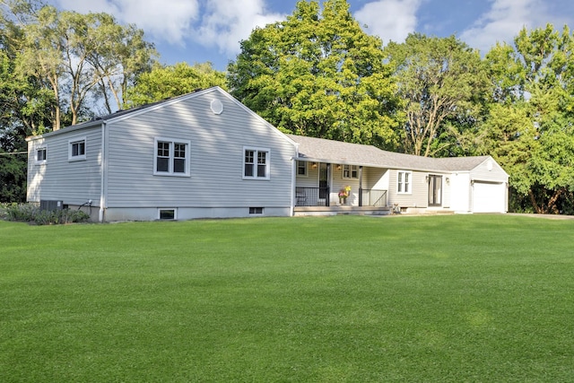 back of house with a garage, a yard, and a porch