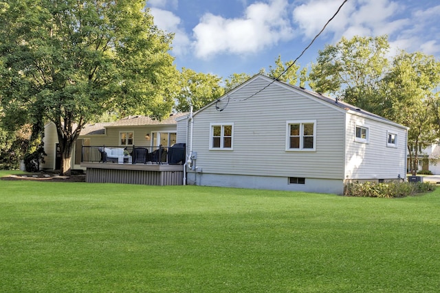 rear view of property with a yard and a deck