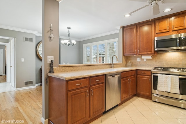 kitchen with stainless steel appliances, visible vents, a sink, and decorative backsplash