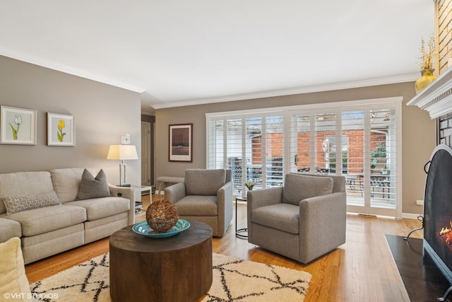 living room with light wood-type flooring, a fireplace with flush hearth, and a wealth of natural light