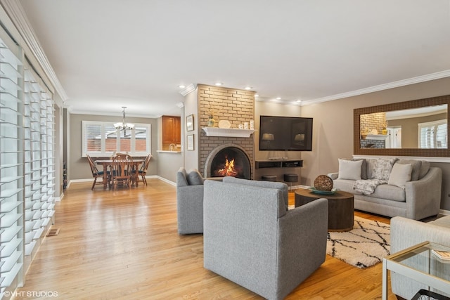 living area with baseboards, visible vents, crown molding, light wood-type flooring, and a fireplace