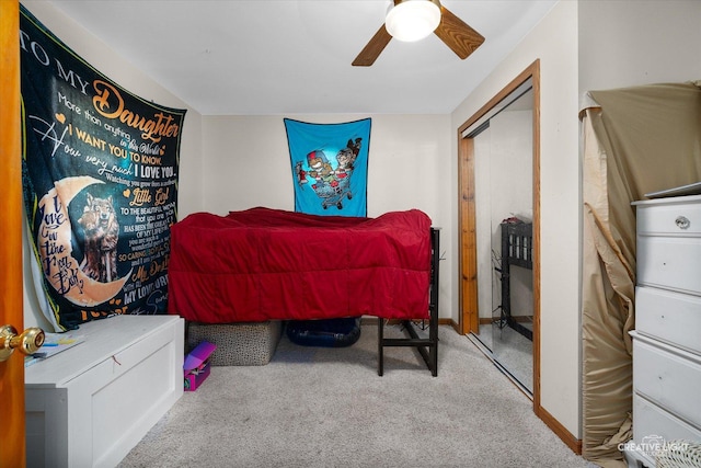 bedroom with light colored carpet, ceiling fan, and a closet