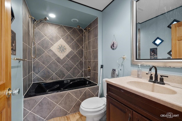 full bathroom featuring vanity, tiled shower / bath combo, and toilet