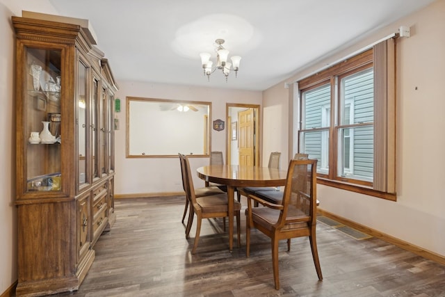 dining area featuring dark hardwood / wood-style floors and an inviting chandelier