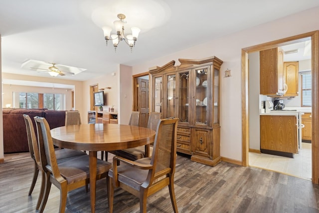 dining room with ceiling fan with notable chandelier and hardwood / wood-style floors