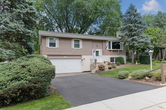 split foyer home with a garage and a front yard