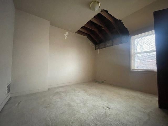 carpeted empty room with vaulted ceiling