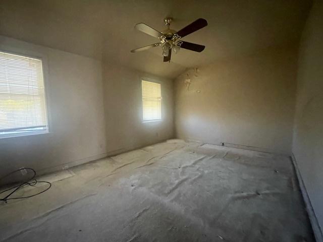 unfurnished room with ceiling fan, vaulted ceiling, and a healthy amount of sunlight