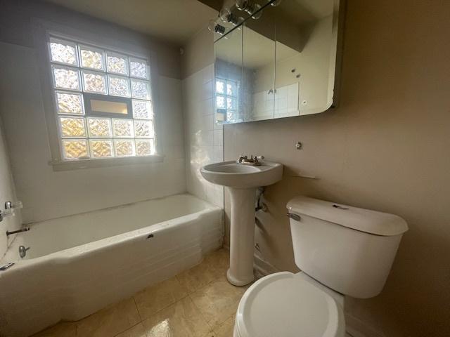 bathroom with tile patterned floors, toilet, and bathing tub / shower combination