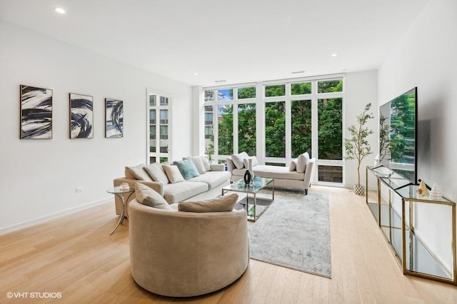 living room with floor to ceiling windows and light wood-type flooring