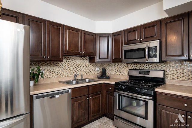 kitchen featuring sink, stainless steel appliances, dark brown cabinetry, light tile patterned flooring, and decorative backsplash