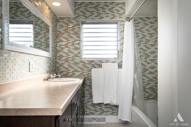 bathroom featuring vanity, tile patterned floors, a healthy amount of sunlight, and shower / bath combo with shower curtain