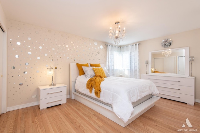 bedroom with an inviting chandelier and light hardwood / wood-style floors