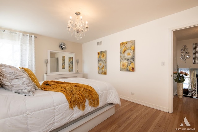 bedroom featuring an inviting chandelier and hardwood / wood-style floors