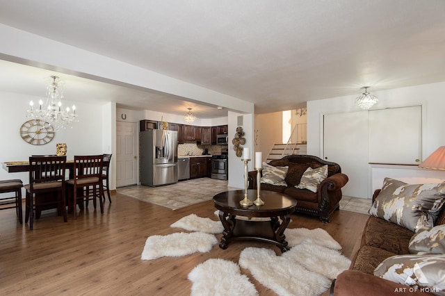 living room with an inviting chandelier and light wood-type flooring