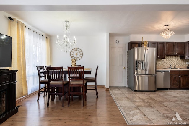 dining space with an inviting chandelier and light hardwood / wood-style floors