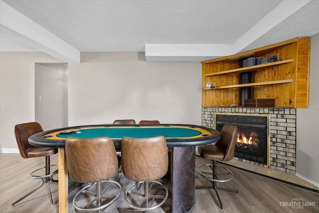 rec room with hardwood / wood-style floors, a fireplace, and a textured ceiling