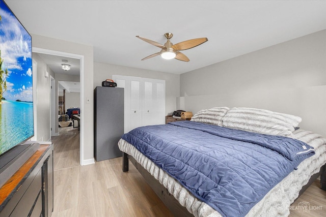 bedroom with ceiling fan, light hardwood / wood-style floors, and a closet