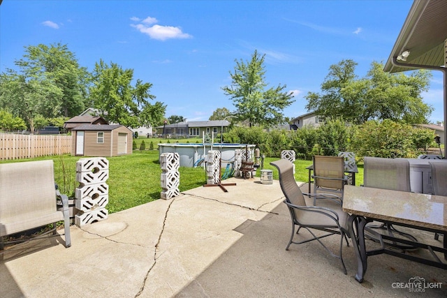 view of patio / terrace with a shed and a fenced in pool