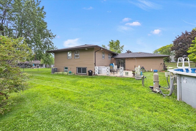 back of property with cooling unit, a patio area, and a lawn