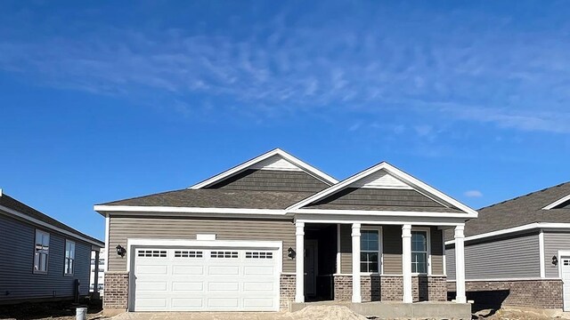 craftsman inspired home with a garage and a yard