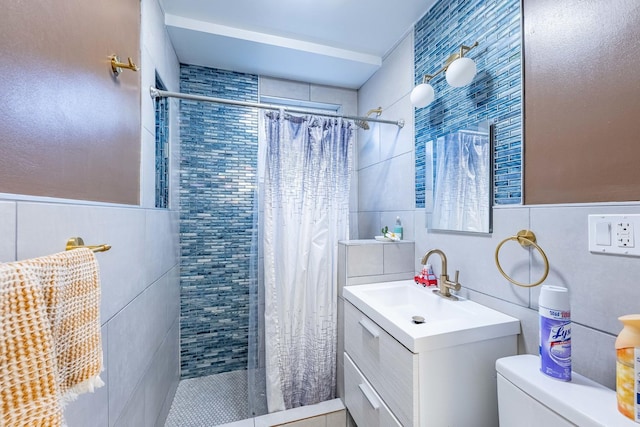 bathroom with vanity, tile walls, toilet, and walk in shower