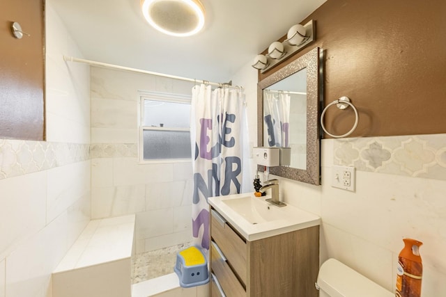 bathroom with a shower with curtain, vanity, tile walls, and toilet