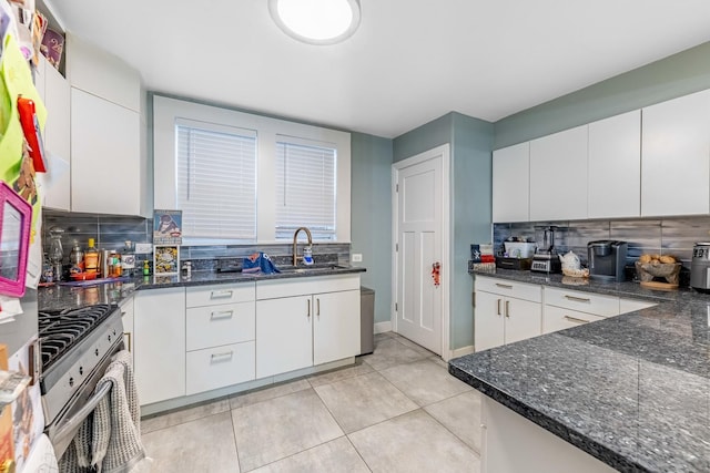 kitchen featuring stainless steel range with gas cooktop, decorative backsplash, and white cabinets