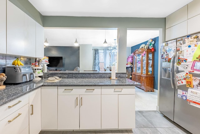 kitchen featuring white cabinetry and stainless steel fridge