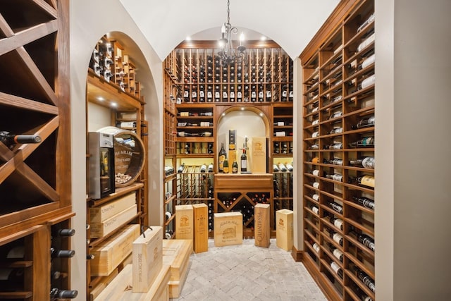 wine area with a chandelier and vaulted ceiling