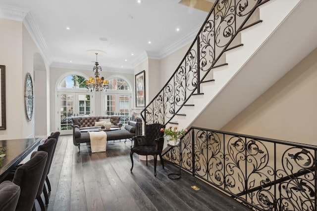 stairway featuring hardwood / wood-style flooring, crown molding, an inviting chandelier, and french doors