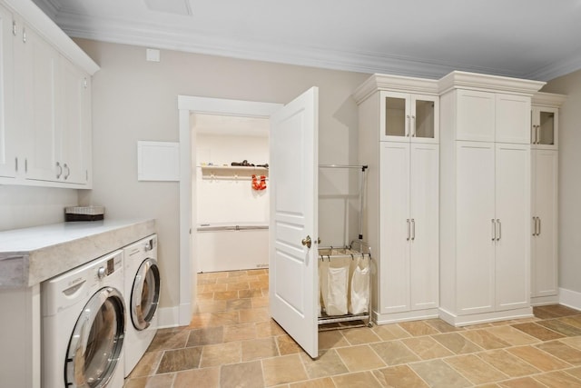 washroom with cabinets, ornamental molding, and washer and dryer