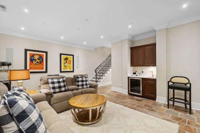 living room with ornamental molding, beverage cooler, and wet bar