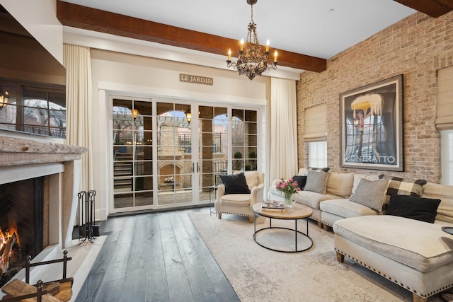 living room with wood-type flooring, a notable chandelier, and beam ceiling