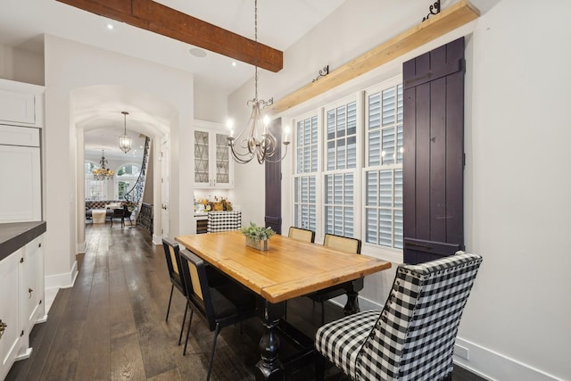 dining area with beamed ceiling, dark wood-type flooring, and a notable chandelier