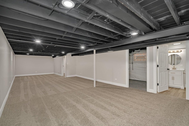 basement featuring light colored carpet and sink