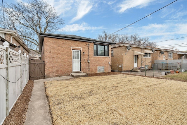 rear view of house featuring a patio, central AC unit, and a lawn