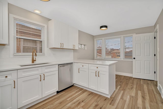 kitchen with sink, white cabinetry, dishwasher, kitchen peninsula, and light hardwood / wood-style floors