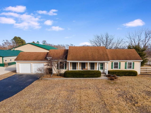 ranch-style house featuring aphalt driveway and a garage