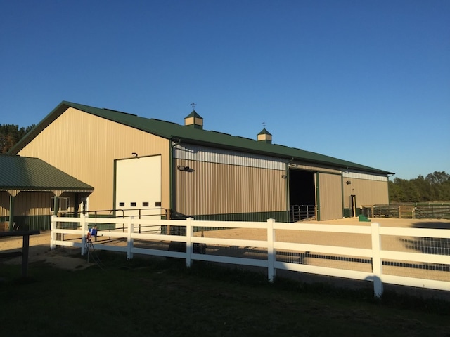 rear view of house with a garage, an outdoor structure, and an exterior structure