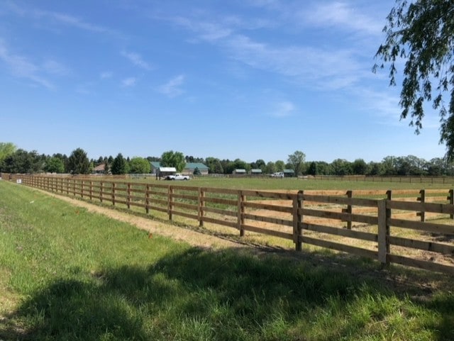 view of yard with fence and a rural view