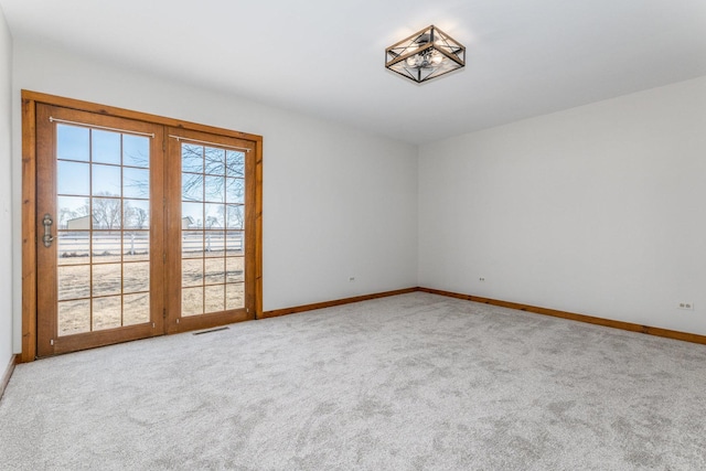 carpeted empty room featuring visible vents and baseboards