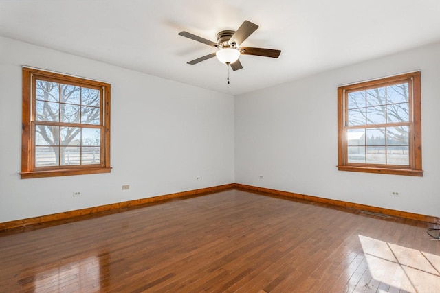 spare room featuring ceiling fan, hardwood / wood-style flooring, and baseboards