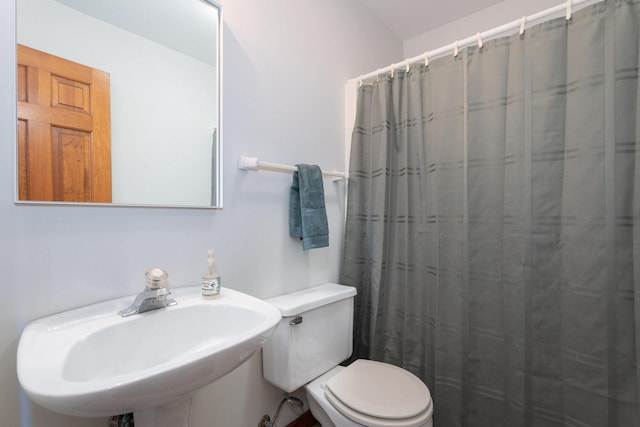 full bath with a sink, toilet, and a shower with curtain