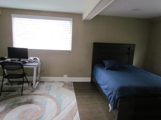 bedroom featuring wood-type flooring and beamed ceiling