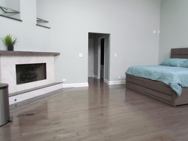 bedroom featuring hardwood / wood-style flooring and a premium fireplace