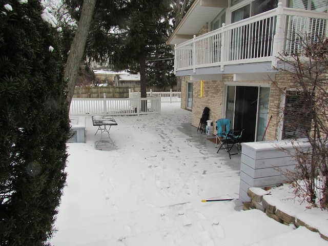 yard covered in snow with a balcony