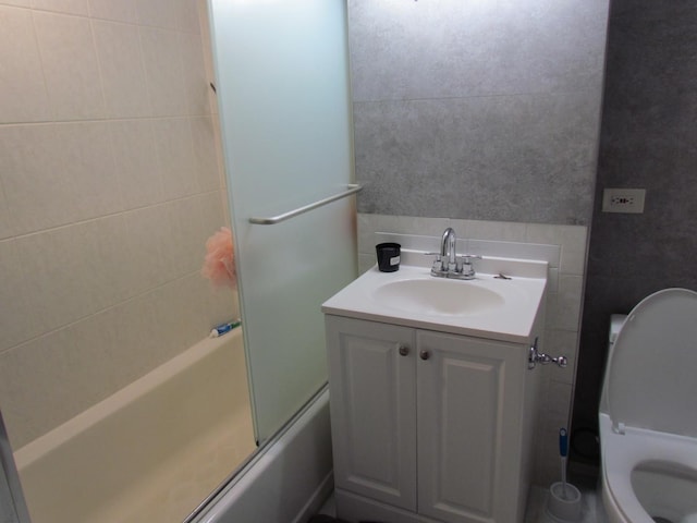 full bathroom featuring enclosed tub / shower combo, vanity, and toilet