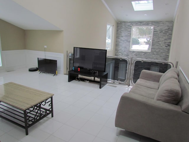 living room with light tile patterned floors and lofted ceiling with skylight