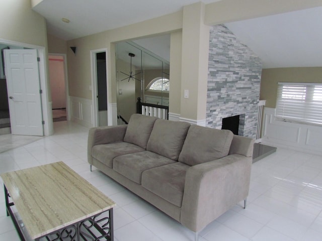 tiled living room with lofted ceiling and a tiled fireplace